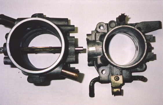 Birds eye view of a Ford XF Falcon throttle body next to a first generation Honda B16A throttle body
